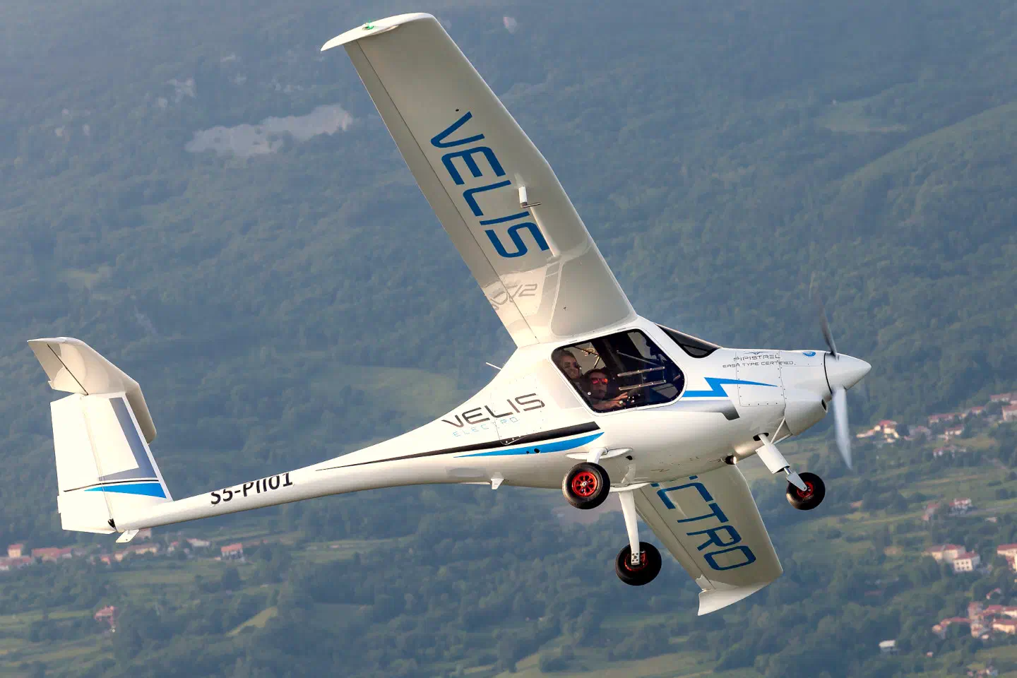 A white single-engine trainer aeroplane in flight.