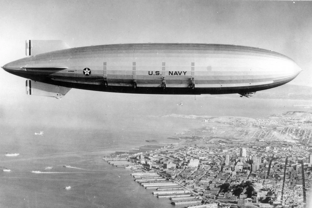 The ZRS-4 USS Akron, a helium-filled rigid airship of the U.S. Navy with a gas volume of 194,000 m3, which first flew in 1931. It was the world’s first flying aircraft carrier. The dark, vertical bands are exhaust water recovery condensers. Credit Navy Lakehurst Historical Society.