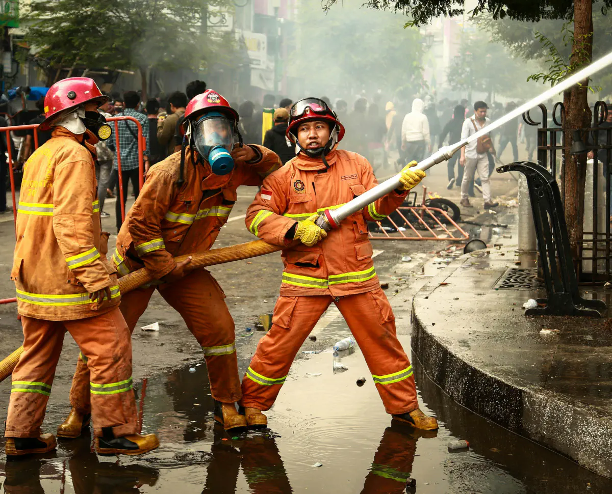 Indonesian firefighters operating a fire hose. ©Ibnu Maulana.